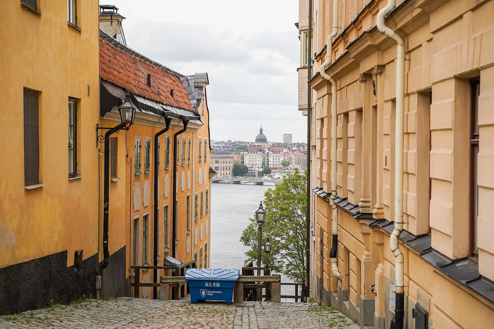 Smal gränd med gula stenhus på Katarina kyrkobacke