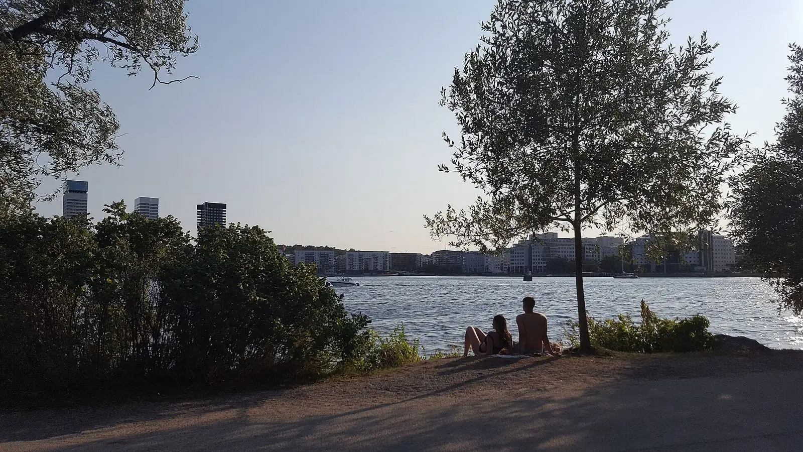 Människor vid vattnet i Tantolunden en sommarkväll