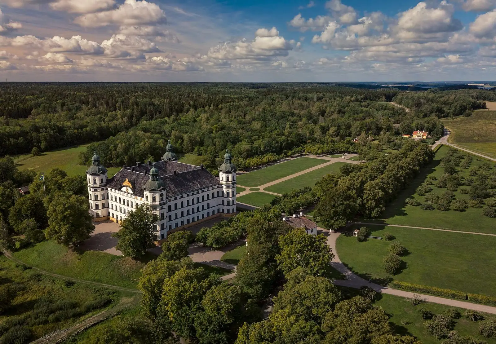 Skoklosters slott och parken från ovan, omgivna av skog och Mälaren