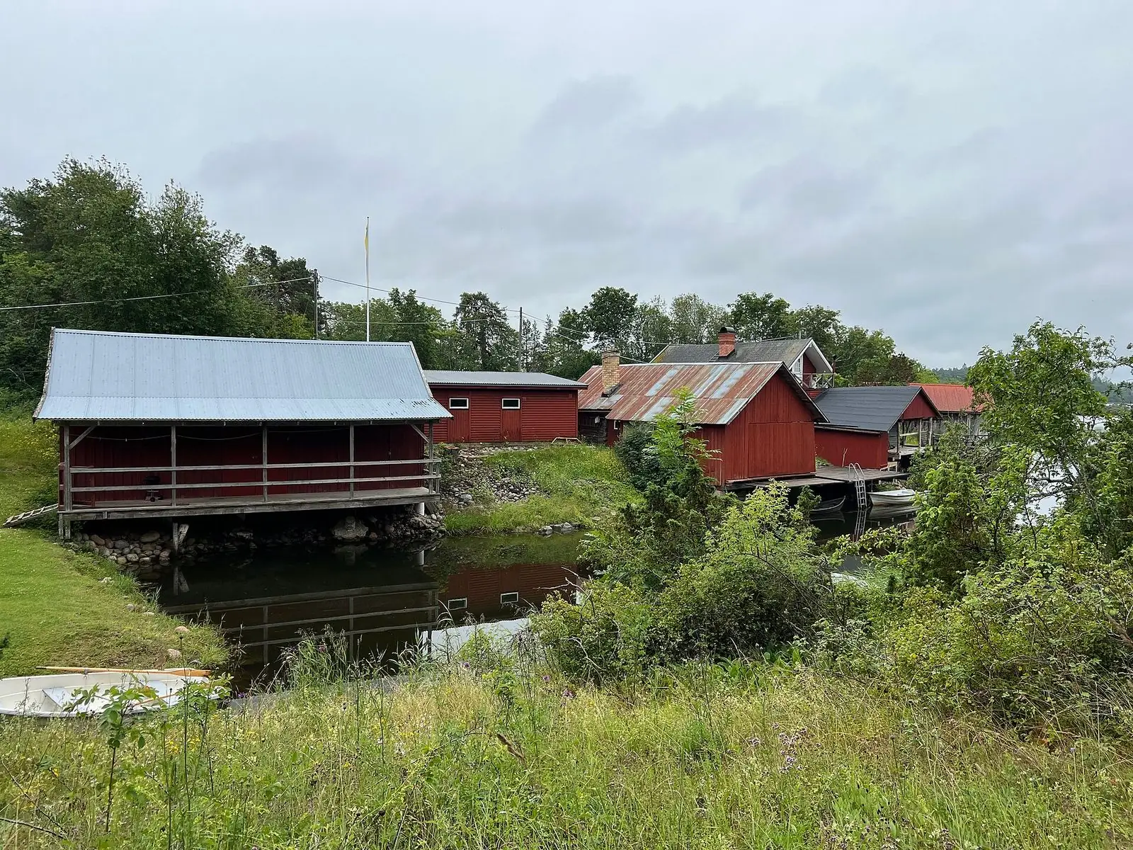 Röda sjöbodar vid en vik på Billudden