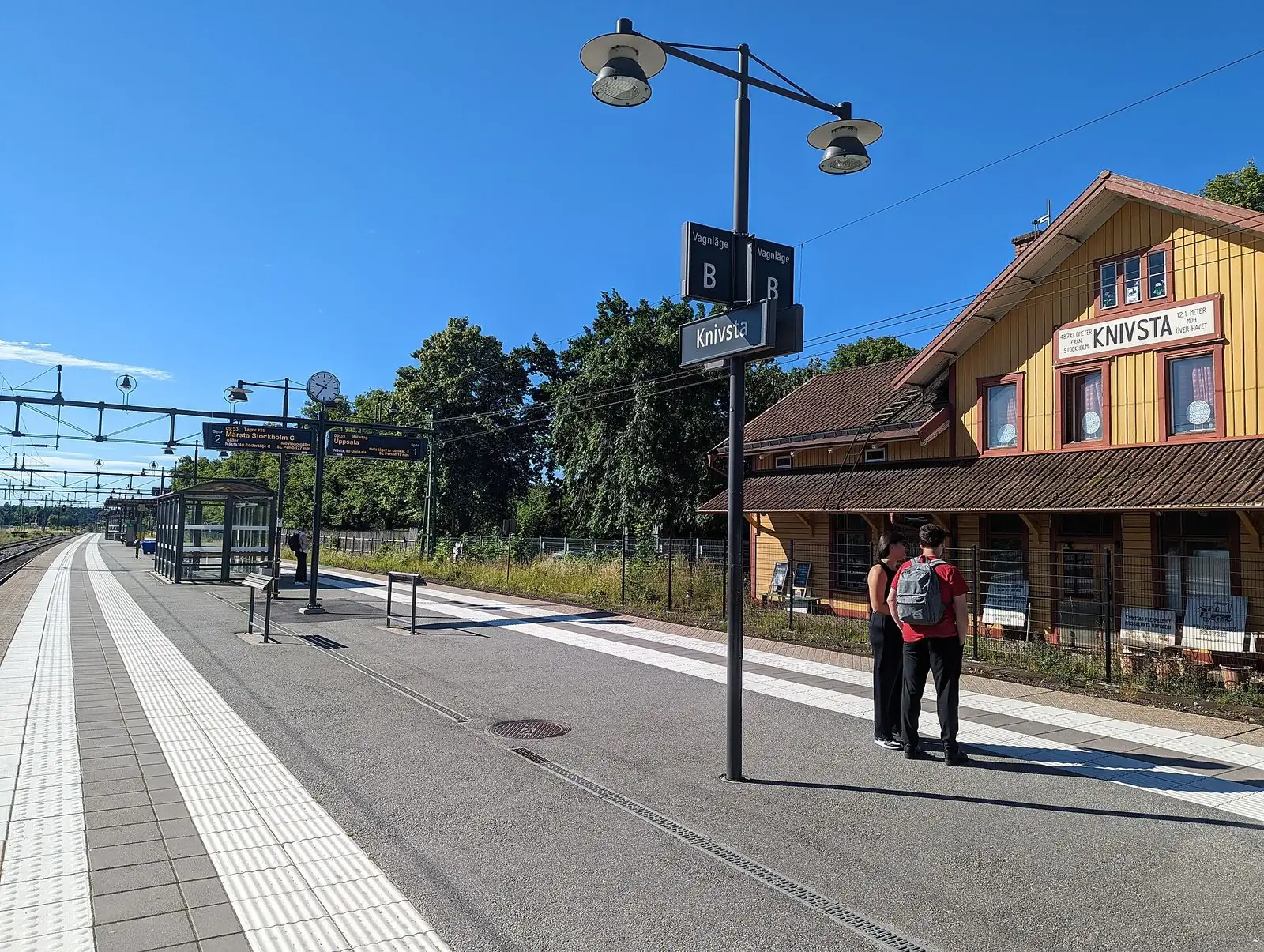 Perrongen på Knivsta station med det gula stationshuset