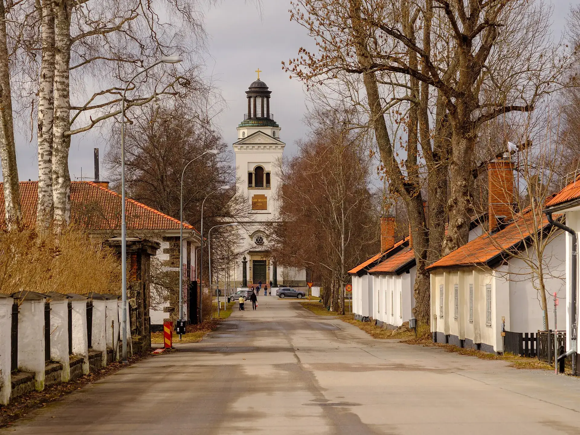 Gata i Söderfors med vita och röda bruksbostäder och kyrkan i fonden