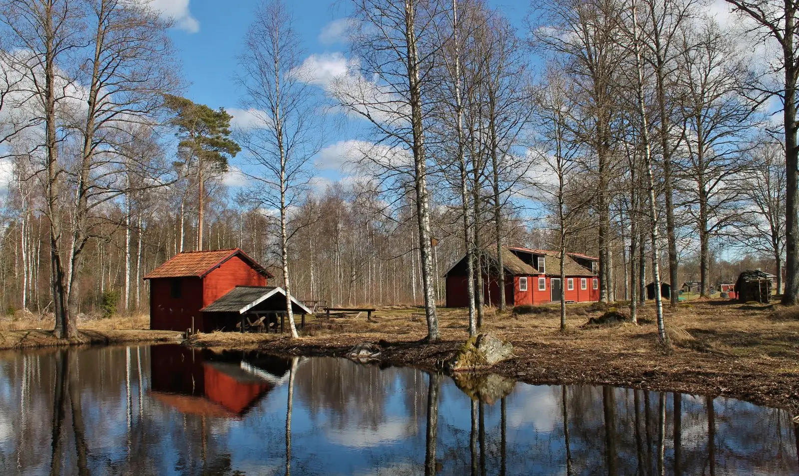 Röda bodar vid en damm i Emmaboda